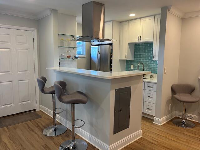 A kitchen features white cabinets, a teal subway tile backsplash, and a breakfast bar — 3170 Holiday Springs Boulevard # 310, Margate FL 33063, MARGATE, FL