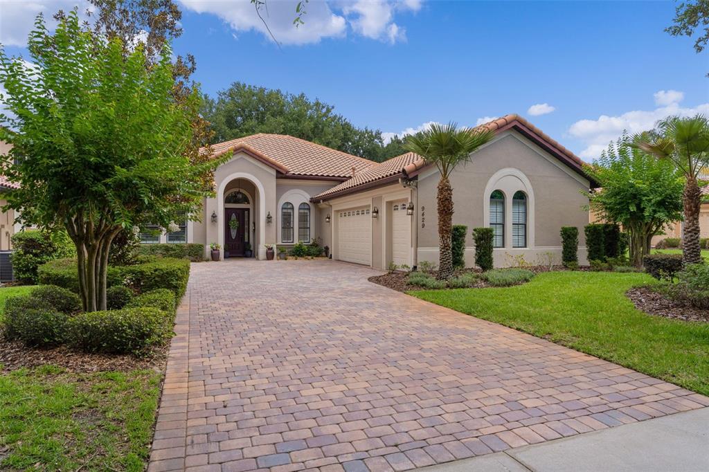 A single-story house with a tiled roof, arched entryway, and a paved driveway — 9429 SAN MIGUEL, HOWEY IN THE HILLS, FL