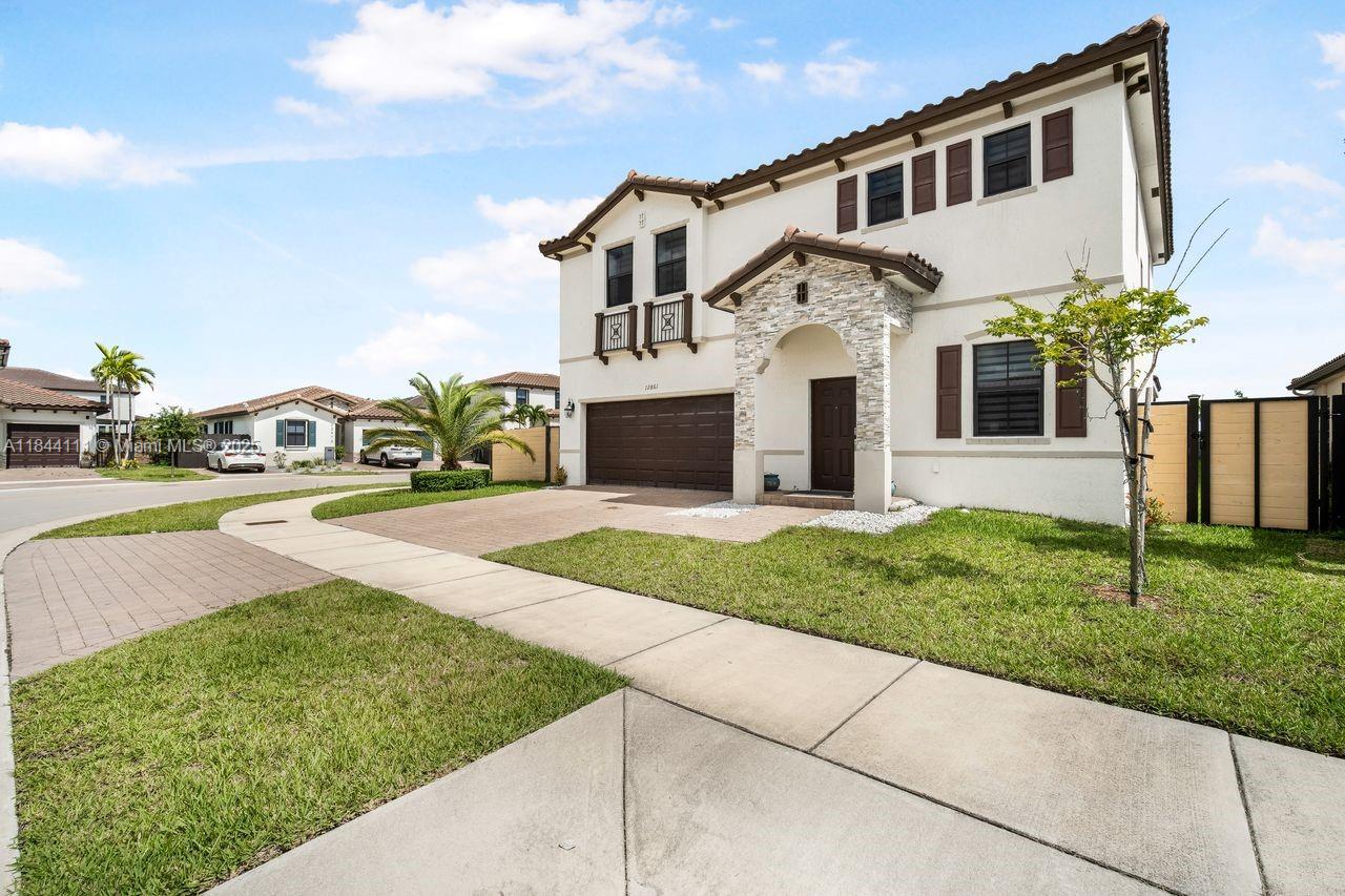 A two-story suburban house with a stone-accented entryway and a two-car garage — 12861 SW 229 th terrace, Miami FL 33170, MIAMI, FL