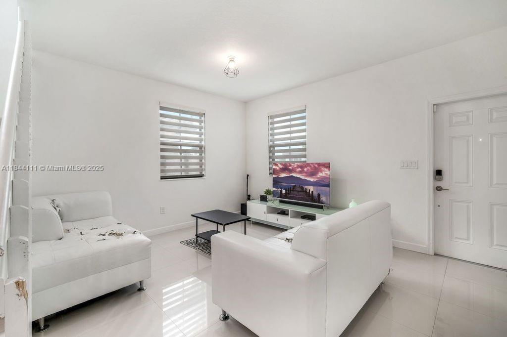 A living room features white walls, tile flooring, two white sofas, and a television console — 12861 SW 229 th terrace, Miami FL 33170, MIAMI, FL