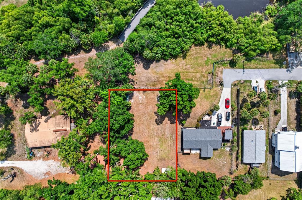 An aerial view shows a vacant rectangular lot bordered by trees and neighboring houses — Lot 8 & 9 NUTMEG AVENUE, SARASOTA, FL