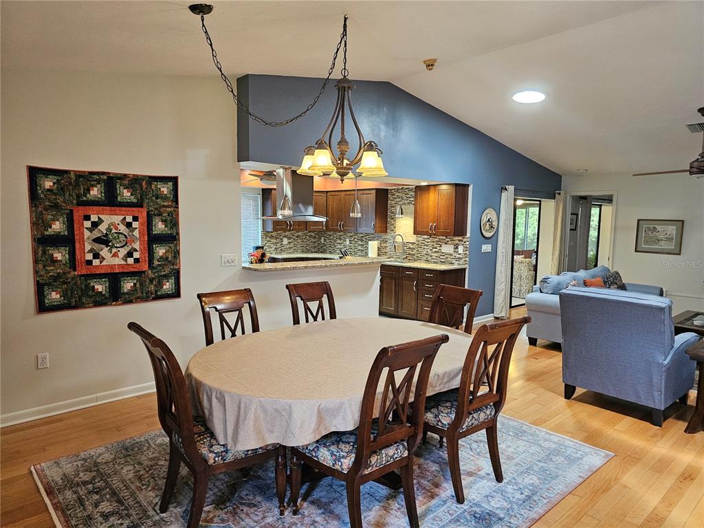 A dining area with a round table and chairs sits in front of an open kitchen — 3441 51ST AVENUE CIRCLE W UNIT 213, BRADENTON, FL