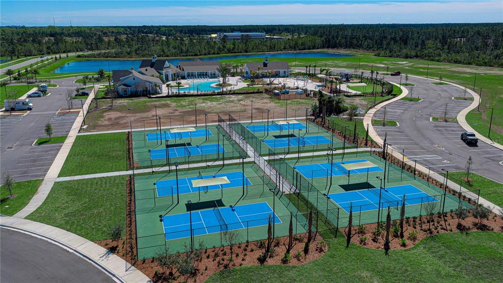 An aerial view shows four pickleball courts next to a community pool and parking lot — 21 HULETT WOODS ROAD, PALM COAST, FL