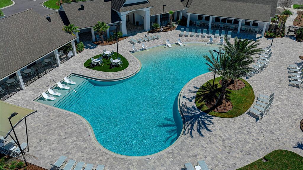 An aerial view of a swimming pool with a sun shelf and surrounding patio area — 21 HULETT WOODS ROAD, PALM COAST, FL