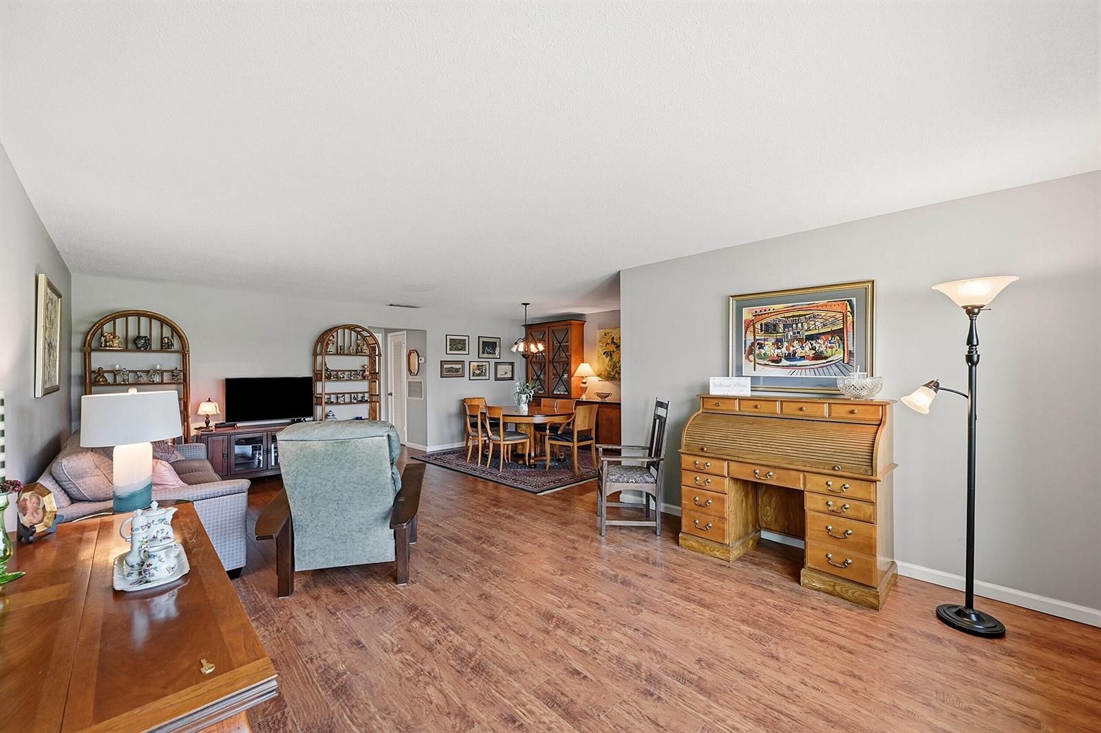 A living and dining area features wood-look flooring, a roll-top desk, and neutral walls — 295 High Point Boulevard # B, Boynton Beach FL 33435, BOYNTON BEACH, FL