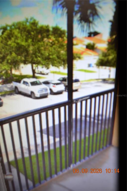 A view from a balcony overlooking a parking lot with several cars and trees — 4323 BAYSIDE VILLAGE DRIVE UNIT 206, TAMPA, FL