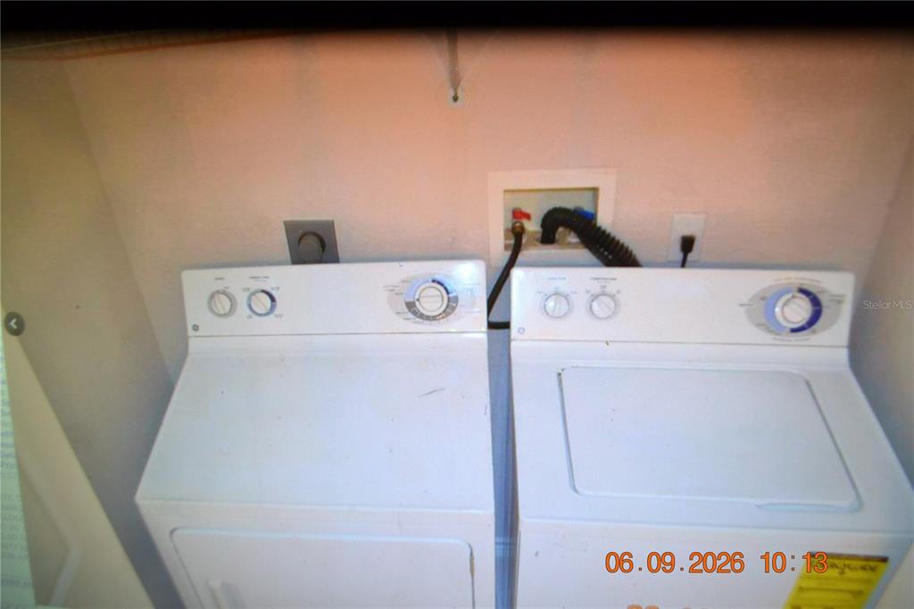 A laundry room contains a white top-loading washing machine and a matching clothes dryer — 4323 BAYSIDE VILLAGE DRIVE UNIT 206, TAMPA, FL