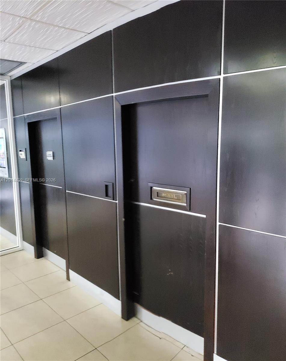 A hallway features dark wood paneling, two recessed doorways, and a built-in mail slot — 850 N Miami Ave # 903, Miami FL 33136, MIAMI, FL