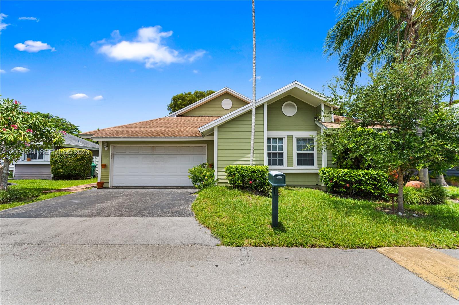 A light green, single-story house features a two-car garage, a driveway, and a front lawn — 10344 SW 141st Ct, Miami FL 33186, MIAMI, FL