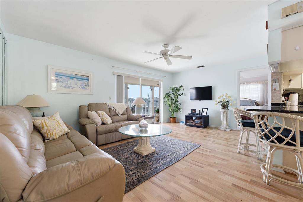 A living room with light wood floors, a beige sofa, and a glass coffee table — 3755 S SCHOOL AVENUE UNIT 41, SARASOTA, FL