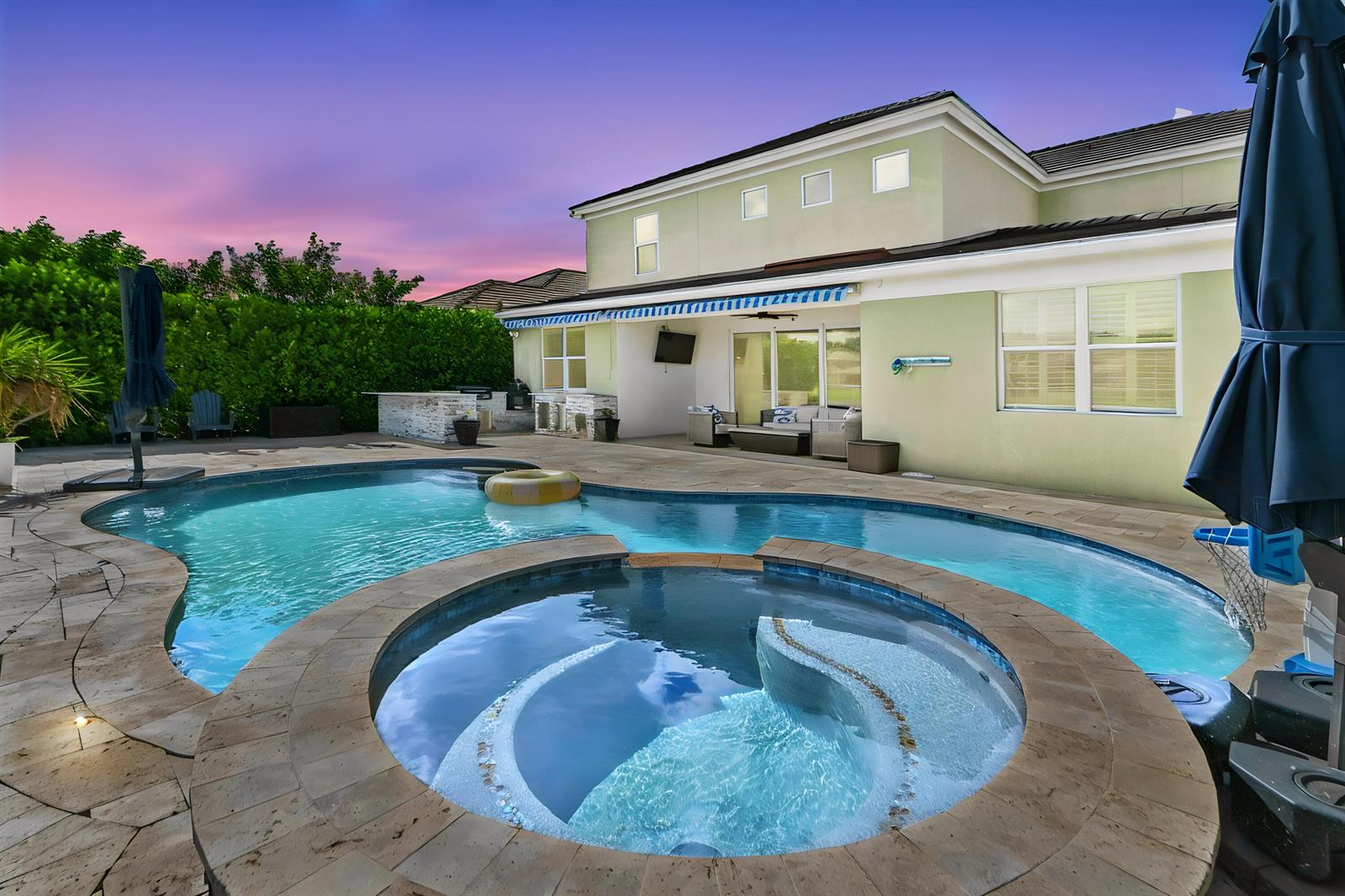 A backyard features a swimming pool with an attached hot tub and a patio area — 9526 Wrangler Drive, Lake Worth FL 33467, LAKE WORTH, FL