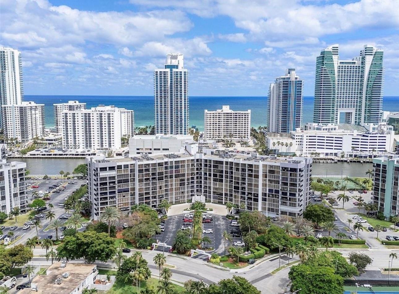 An aerial view shows a large residential complex with parking lots near a coastal waterway — 1000 Parkview Dr # 528, Hallandale Beach FL 33009, HALLANDALE BEACH, FL