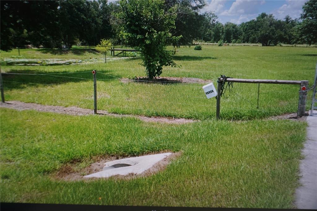 A grassy field features a wire fence, a mailbox, and a concrete drainage culvert — 40906 11TH AVENUE E, MYAKKA CITY, FL