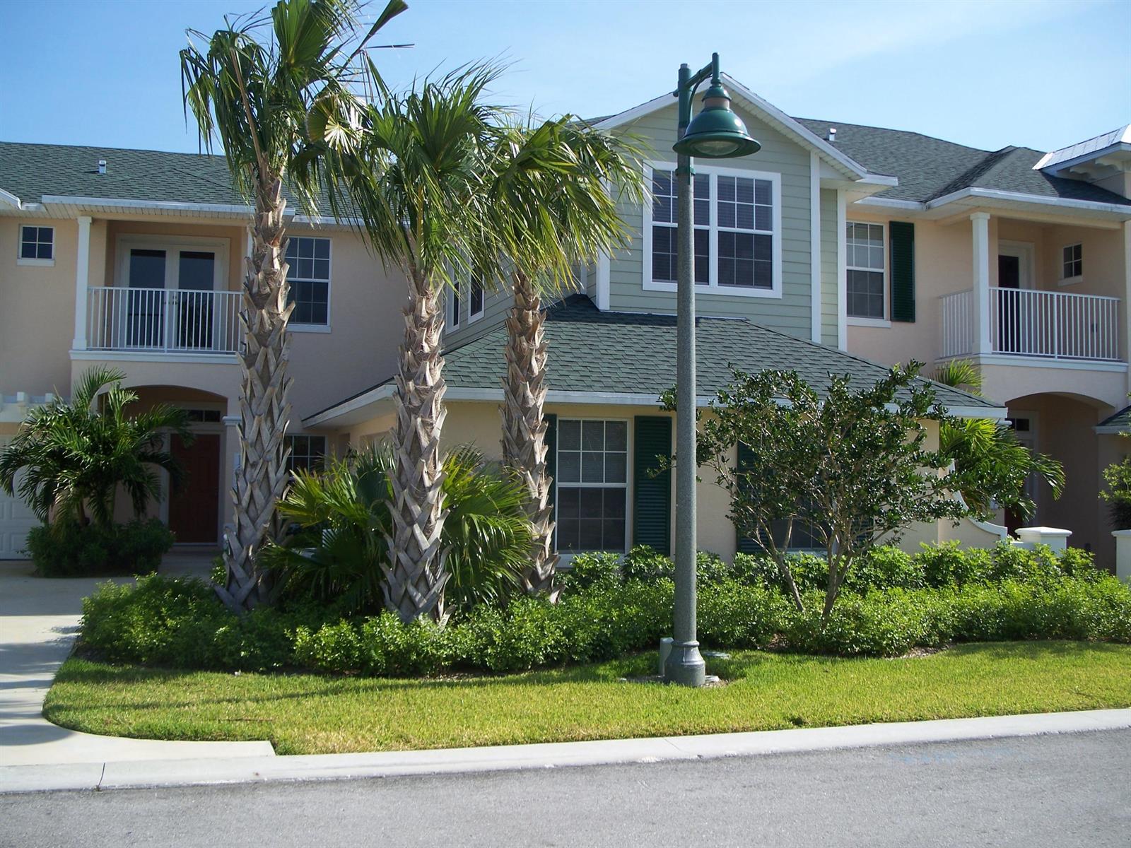 A two-story residential building with palm trees, a street lamp, and green landscaping in front — 1645 Baseline Lane, Vero Beach FL 32967, VERO BEACH, FL