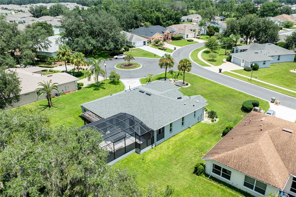 An aerial view of a suburban house with a screened-in pool patio and large yard — 5121 AURORA DRIVE, LEESBURG, FL