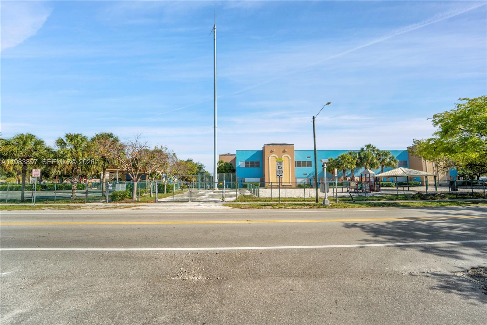 A school building with a fenced playground is visible across a paved road — 919 Hillcrest Dr # 210, Hollywood FL 33021, HOLLYWOOD, FL