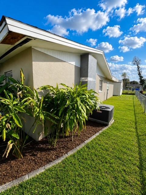 The exterior of a house features a tan wall, a gray chimney, and lush green plants — 3756 EDISON AVENUE, FORT MYERS, FL