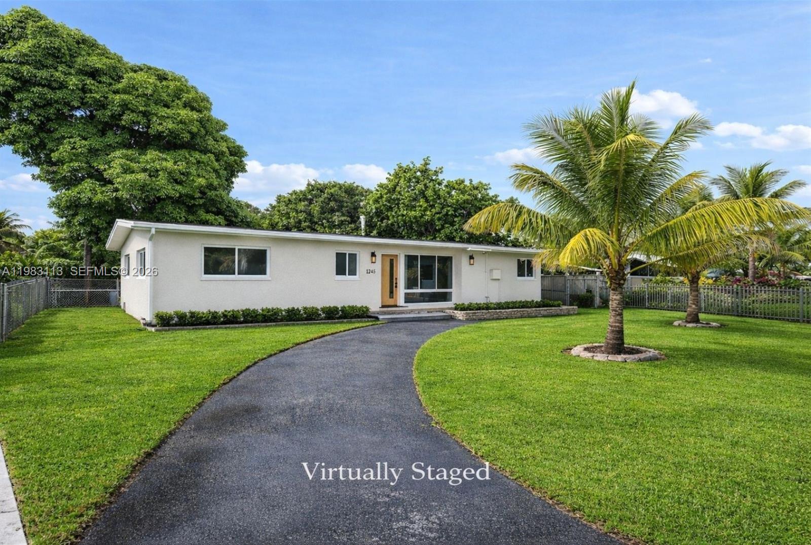 A single-story house with a curved driveway and palm trees on a grassy lawn — 550 NE 173rd St, North Miami Beach FL 33162, NORTH MIAMI BEACH, FL