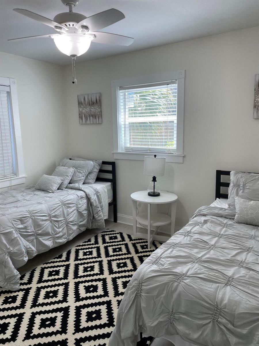 A bedroom features two twin beds, a patterned area rug, and a central ceiling fan — 1609 N M Street, FL 33460, FL