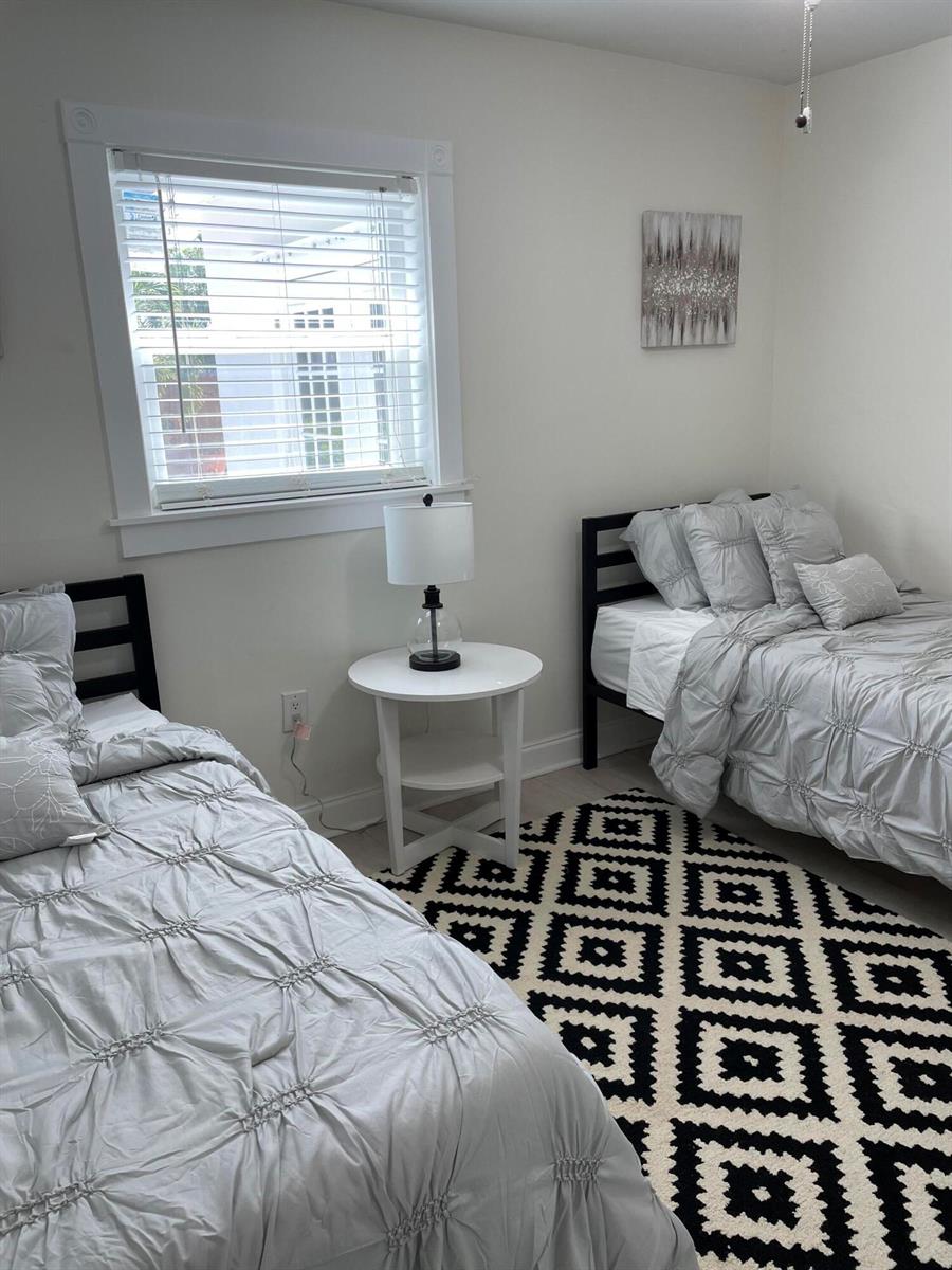 A bedroom features two twin beds, a central nightstand, and a black-and-white patterned rug — 1609 N M Street, FL 33460, FL