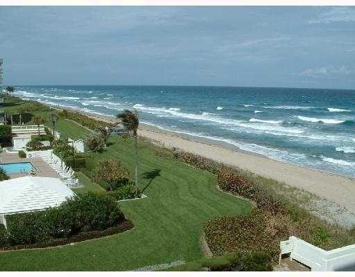 An elevated view of a grassy lawn, a swimming pool, and a sandy beach shoreline — 3450 S Ocean Boulevard # 406, Palm Beach FL 33480, PALM BEACH, FL