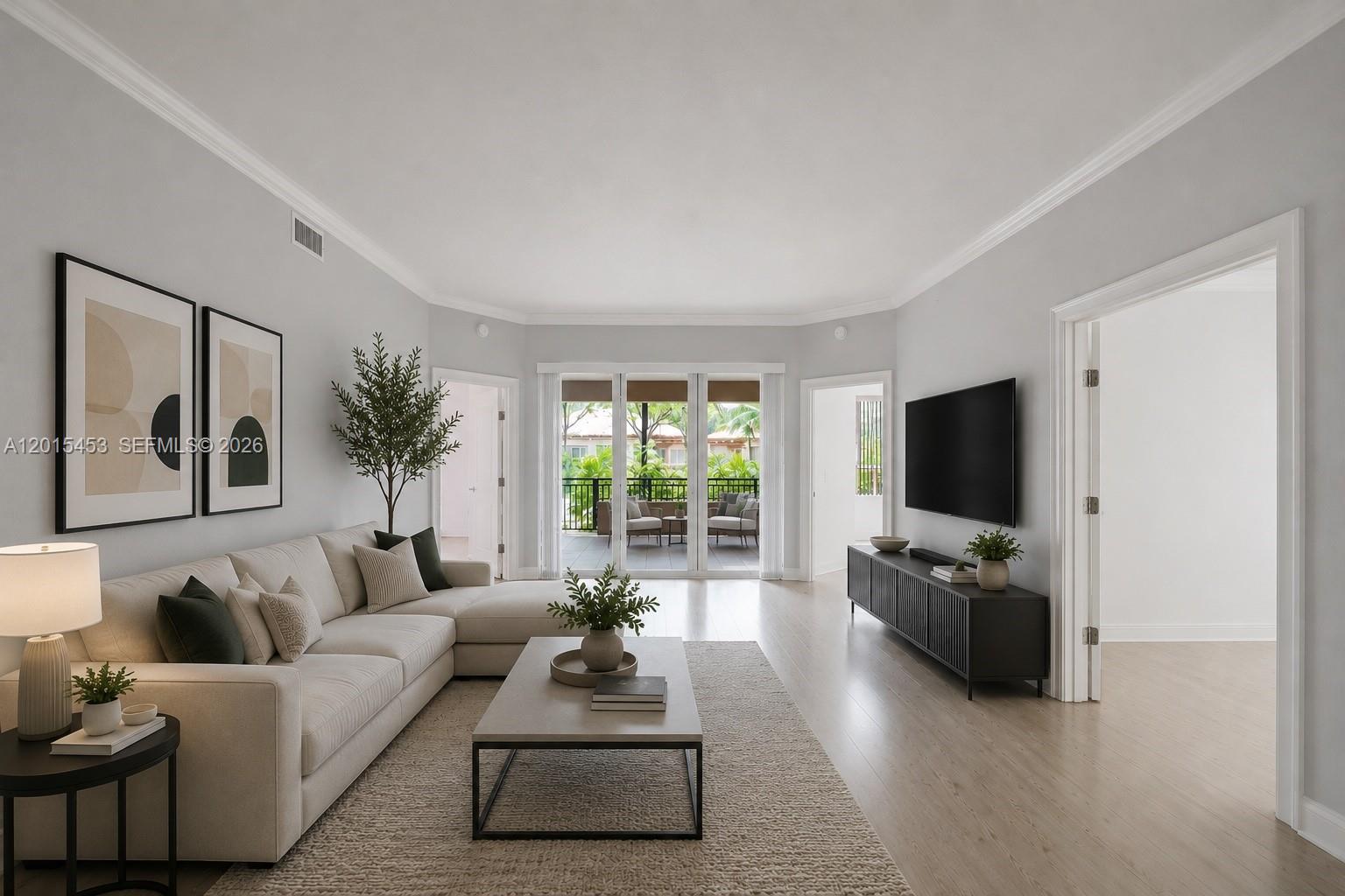 A living room features a beige sectional sofa, a coffee table, and a wall-mounted television — 16135 Emerald Estates Dr # 166, Weston FL 33331, WESTON, FL