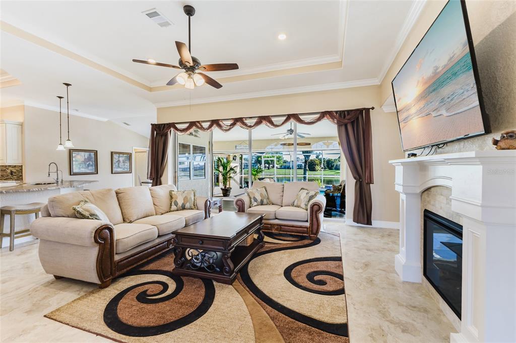 A living room features a fireplace, a large area rug, and sliding doors to a patio — 1900 NUREMBERG BOULEVARD, PUNTA GORDA, FL