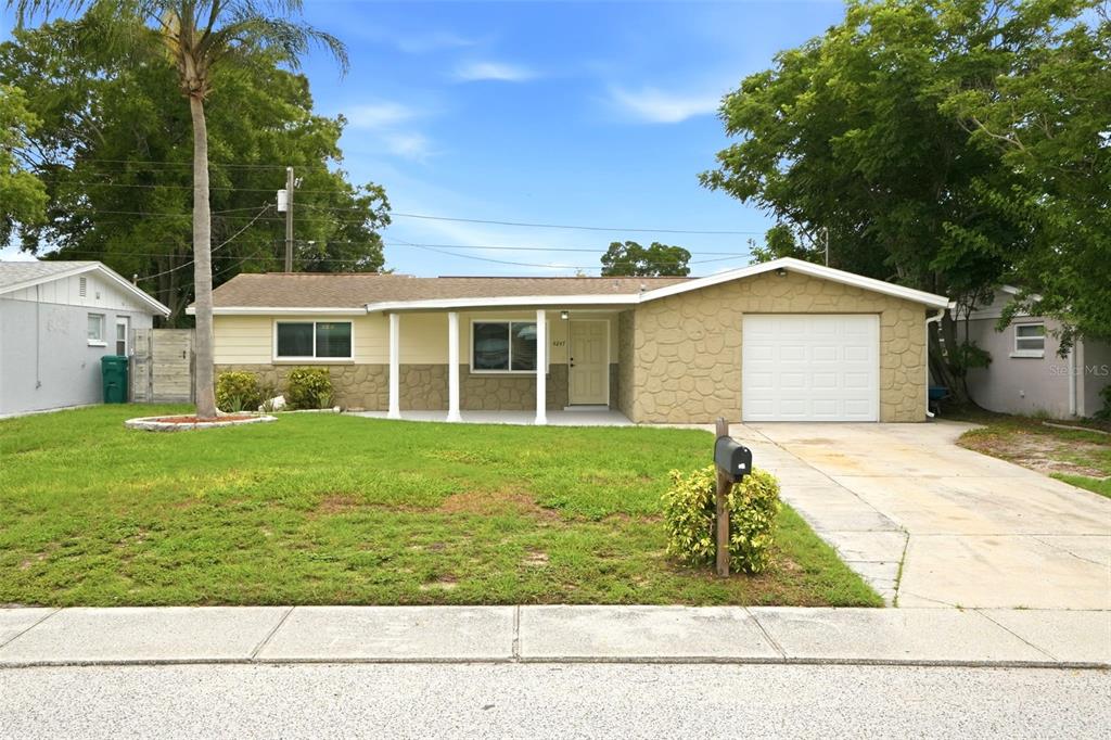 A single-story house with a stone facade, a front porch, and an attached garage — 4247 GULFSHORE COURT, NEW PORT RICHEY, FL