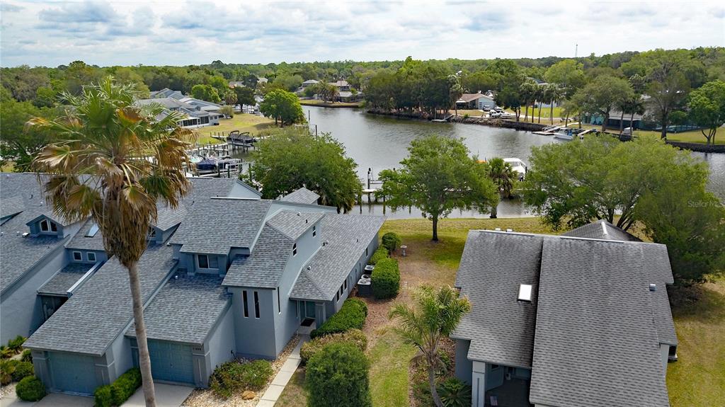 An aerial view shows two gray multi-story houses situated along a canal with boat docks — 11040 W COVE HARBOR DRIVE, CRYSTAL RIVER, FL