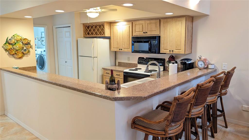 A dining area with a glass table, wicker chairs, and tile flooring near a staircase — 11040 W COVE HARBOR DRIVE, CRYSTAL RIVER, FL