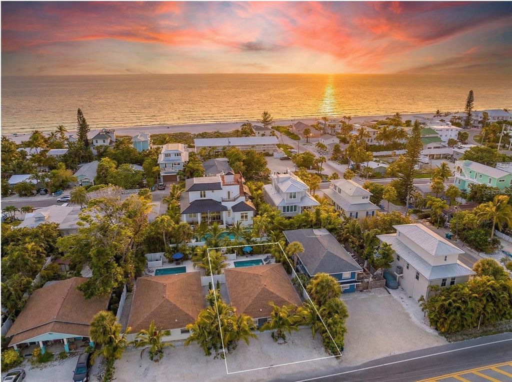 An aerial view shows a coastal neighborhood with a highlighted house near the beach — 3016 GULF DRIVE, HOLMES BEACH, FL
