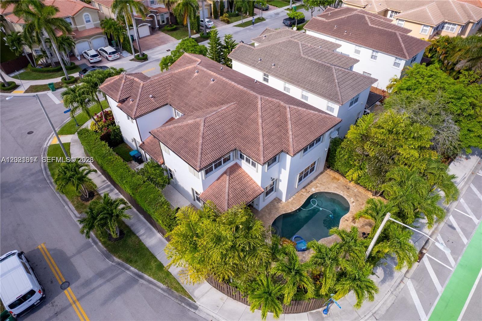 An aerial view shows a two-story house with a tile roof and a backyard pool — 11530 NW 82nd Ter, Doral FL 33178, DORAL, FL
