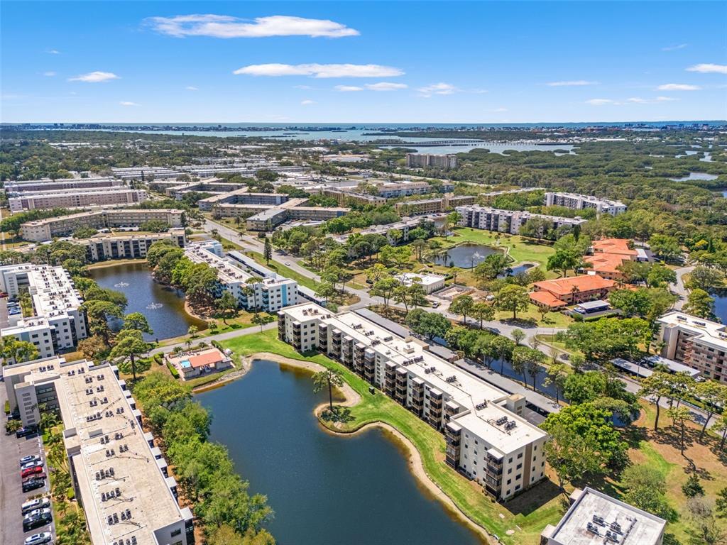 An aerial view shows multiple apartment buildings surrounding several ponds in a suburban landscape — 6070 80TH STREET N UNIT 410, ST PETERSBURG, FL