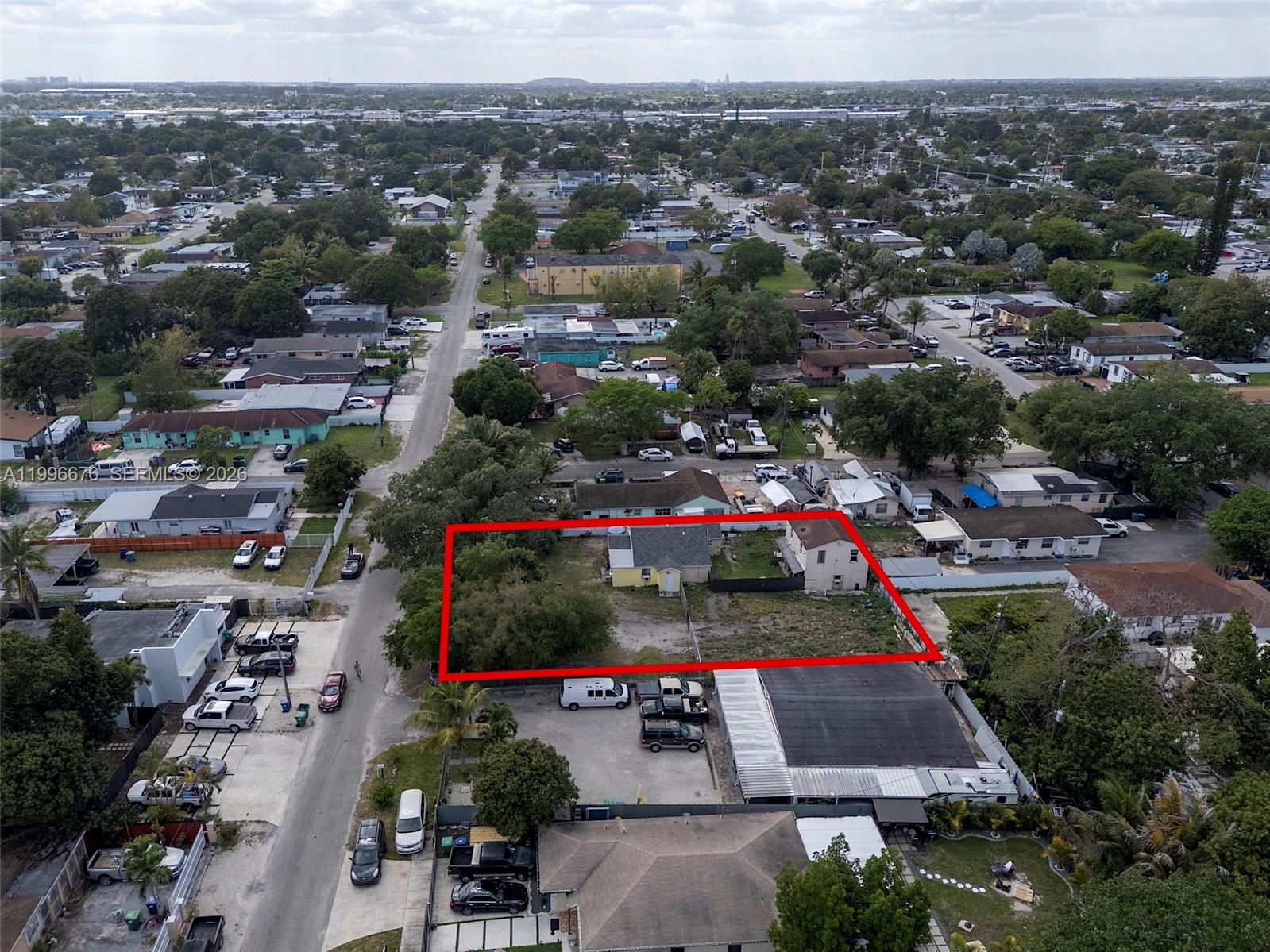 An aerial view shows a rectangular property lot outlined in red containing two small houses — 3035 NW 93rd St, Miami FL 33147, MIAMI, FL