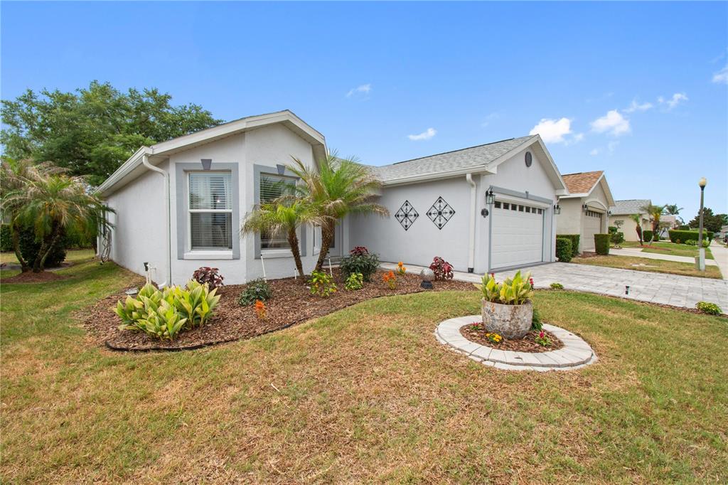 A single-story house with a gray exterior, a two-car garage, and a landscaped front yard — 241 LOURDES STREET, LAKE WALES, FL