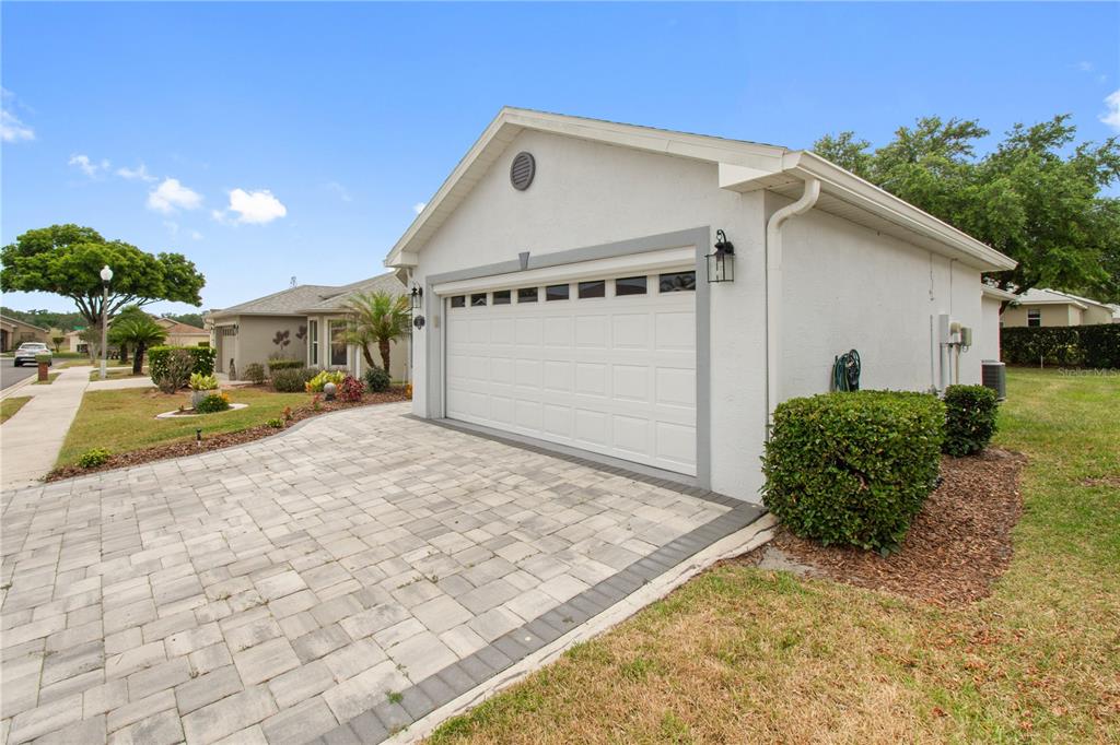 A white house with a two-car garage and a paved driveway under a blue sky — 241 LOURDES STREET, LAKE WALES, FL