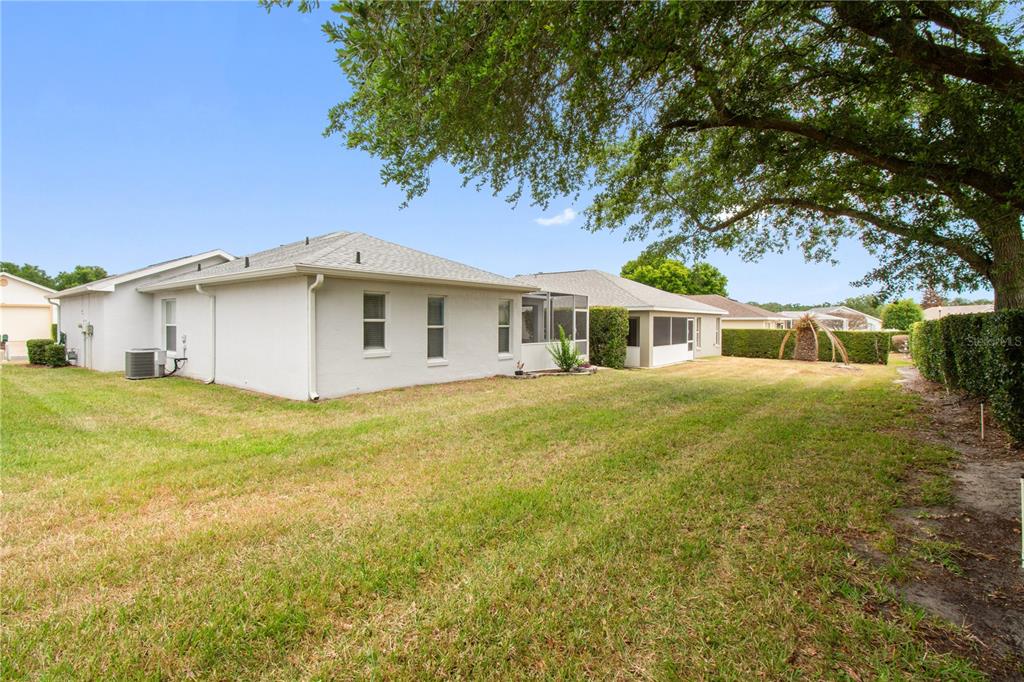 The exterior view shows the back of a light-colored house with a screened-in porch — 241 LOURDES STREET, LAKE WALES, FL