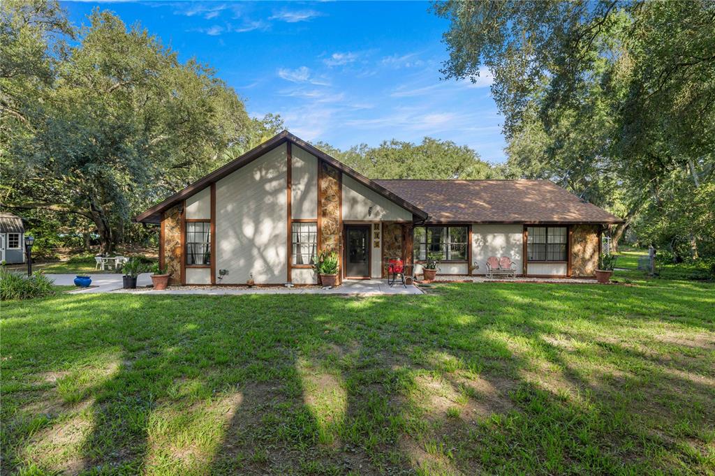 A single-story house with stone accents and a gabled roof sits on a grassy lot — 16250 SW 20TH AVENUE ROAD, OCALA, FL