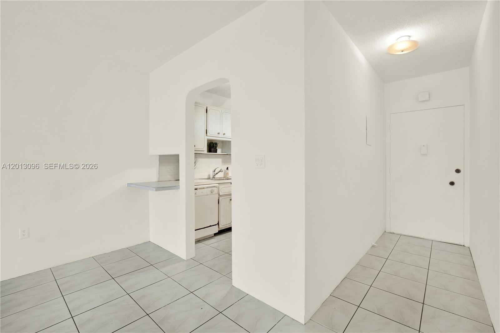 A tiled entryway leads to a kitchen visible through an arched doorway — 285 NE 191st St # 2911, Miami FL 33179, MIAMI, FL