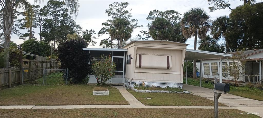 A single-story mobile home features a screened front porch, a carport, and a chain-link fence — 5321 CHRISTIANCY AVENUE, PORT ORANGE, FL