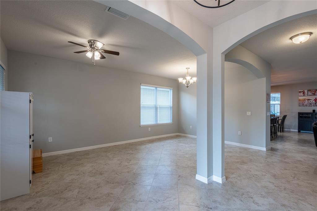 An open-concept living area features light gray walls, tile flooring, and arched architectural transitions — 11862 LAKE LUCAYA DRIVE, RIVERVIEW, FL