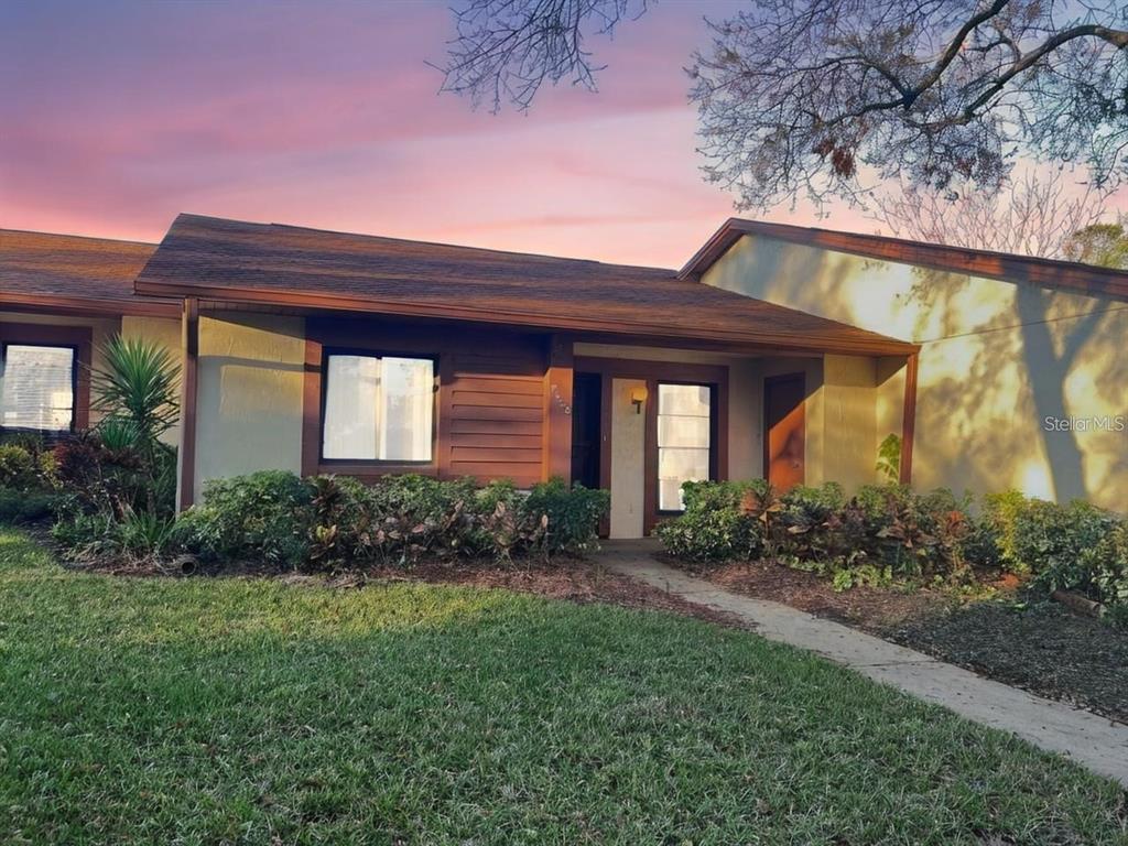 A single-story house with a brown shingled roof, tan stucco walls, and a front walkway — 7523 GREYSTONE DRIVE, HUDSON, FL