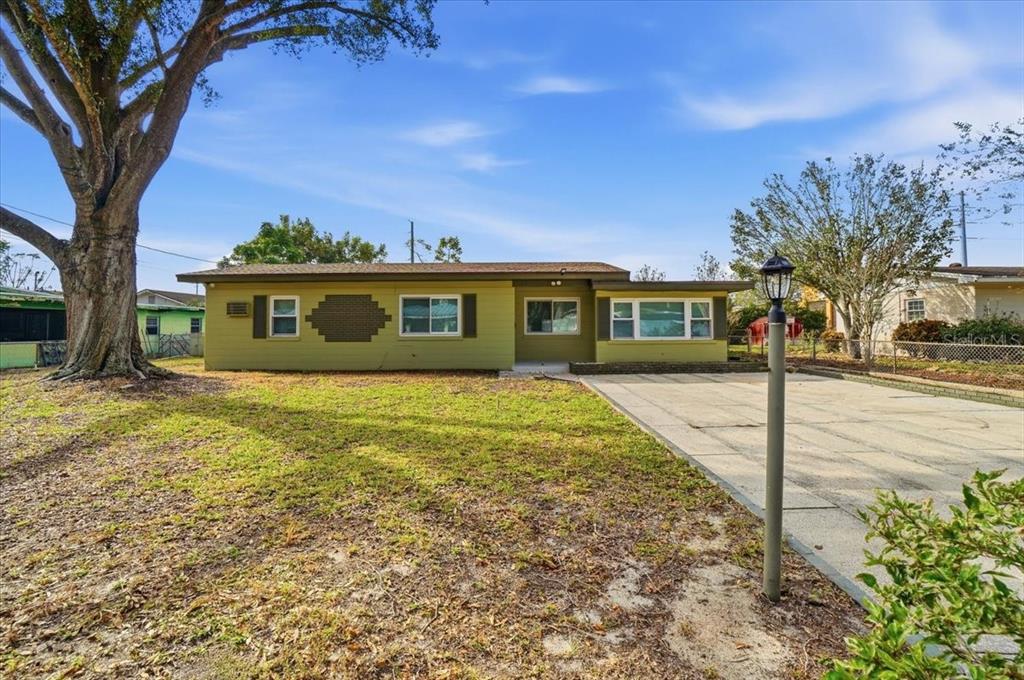 A single-story house with olive green siding, a large tree, and a concrete driveway — 3022 HICKORY STREET NW, WINTER HAVEN, FL