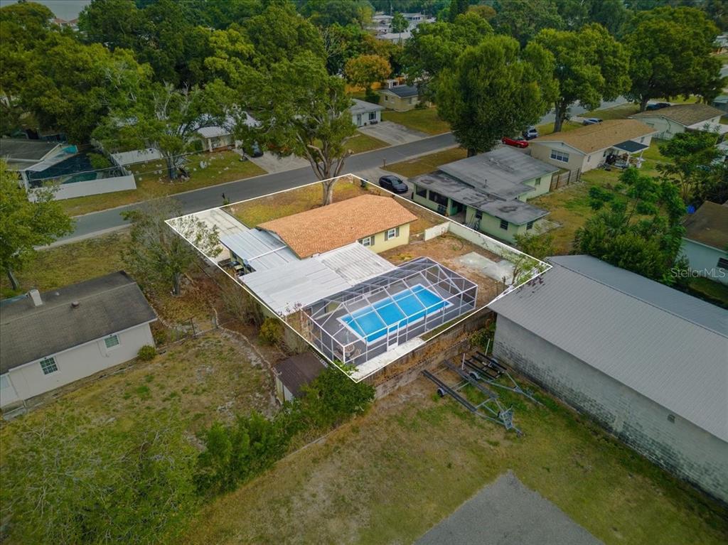An aerial view shows a single-story house with a screened-in pool and a fenced yard — 3022 HICKORY STREET NW, WINTER HAVEN, FL