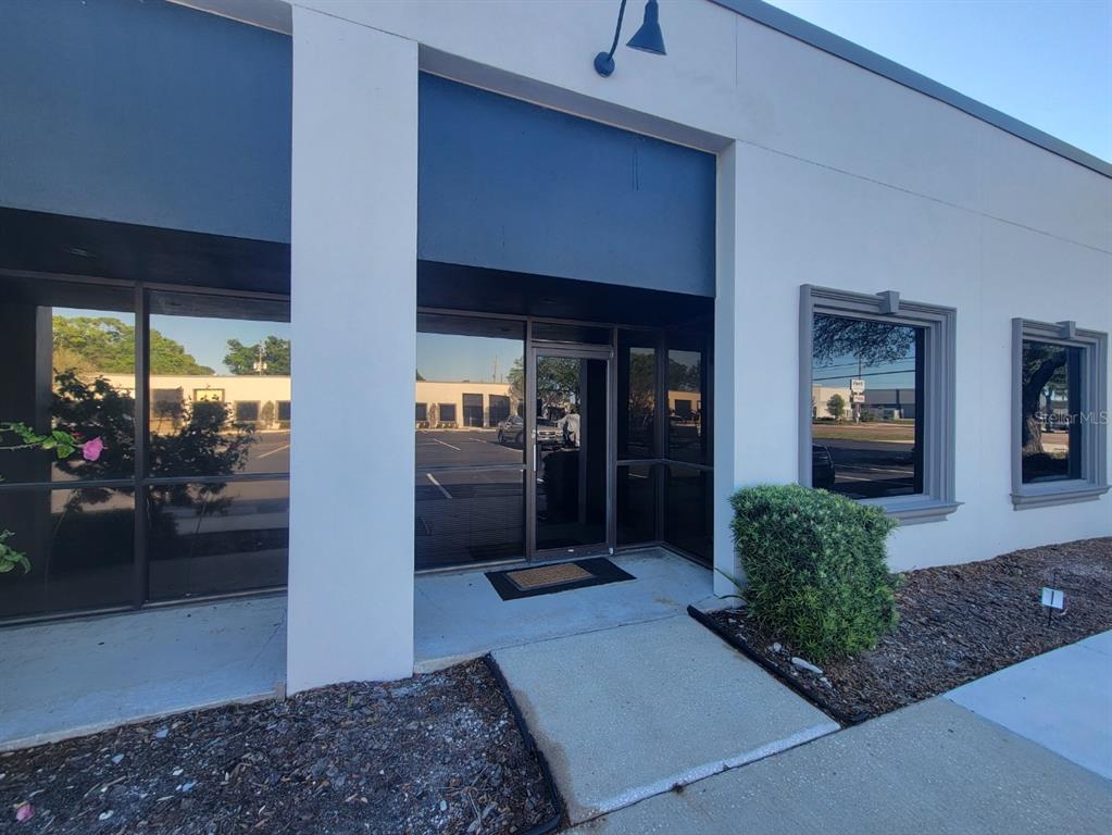 The exterior of a commercial building features a glass entrance door and large tinted windows — 9225 ULMERTON ROAD UNIT N, LARGO, FL