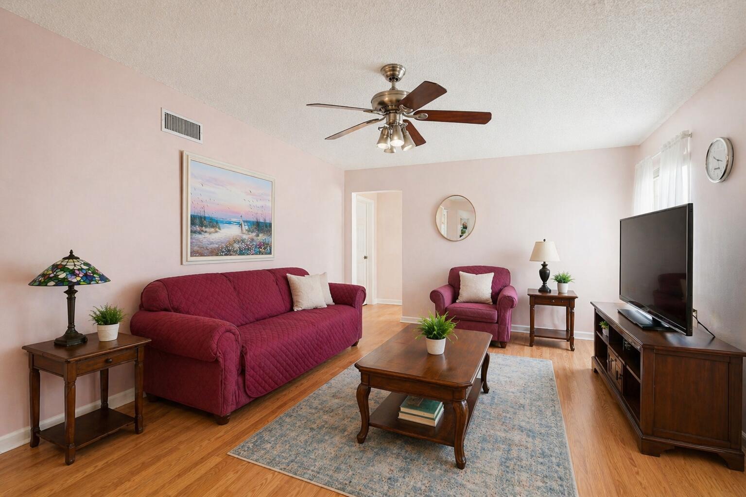 A living room features a magenta sofa and armchair, a coffee table, and a television — 5760 Pine Wood Drive # 1, FL 33463, FL