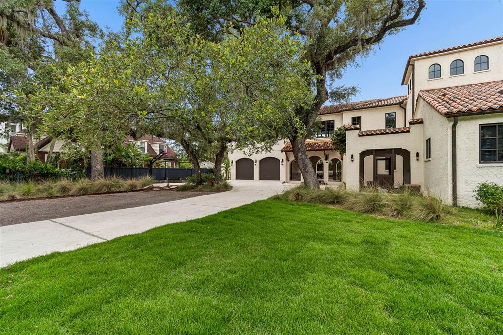 A two-story stucco house with a tile roof, arched windows, and a concrete driveway — 2603 S PARKVIEW STREET, TAMPA, FL