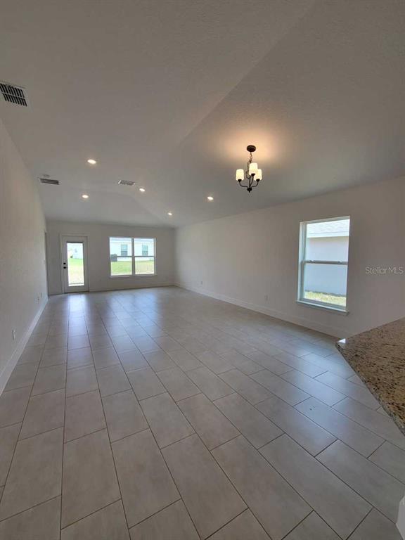An open-concept living area features light-colored tile flooring, recessed lighting, and a chandelier — 4392 SW 92ND PLACE ROAD, OCALA, FL