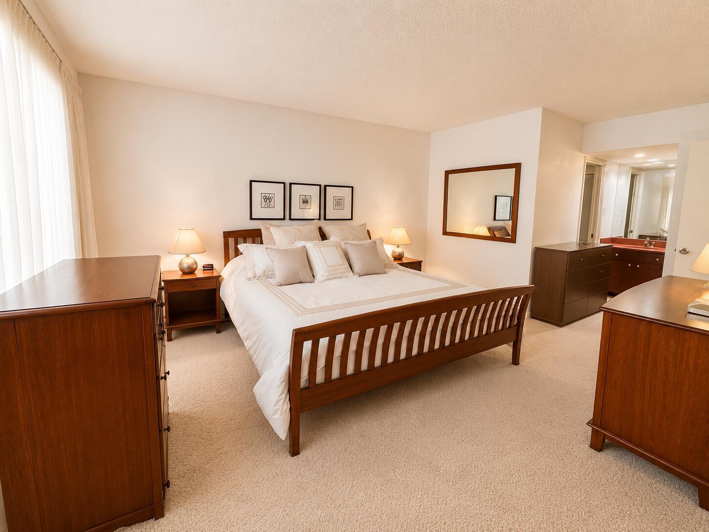 A bedroom features a wooden bed frame, two nightstands, two dressers, and a mirror — 4200 Oaks Terrace # 104, Pompano Beach FL 33069, POMPANO BEACH, FL