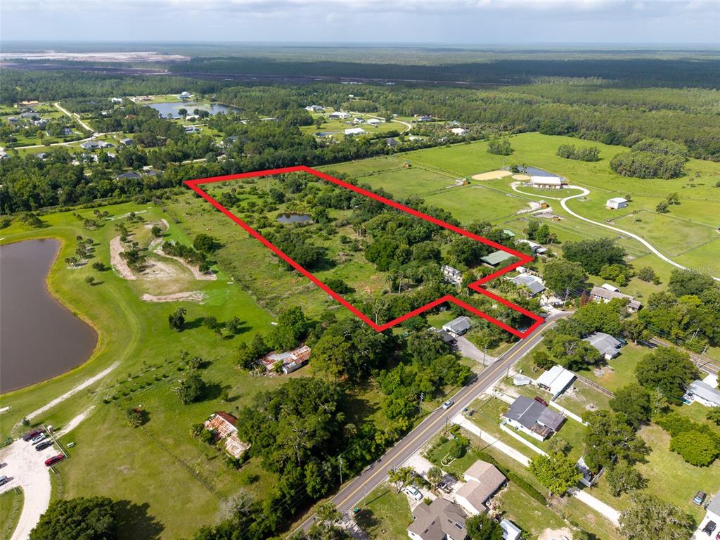An aerial view shows a rectangular plot of land outlined in red near a road — 1405 S GLENCOE ROAD, NEW SMYRNA BEACH, FL